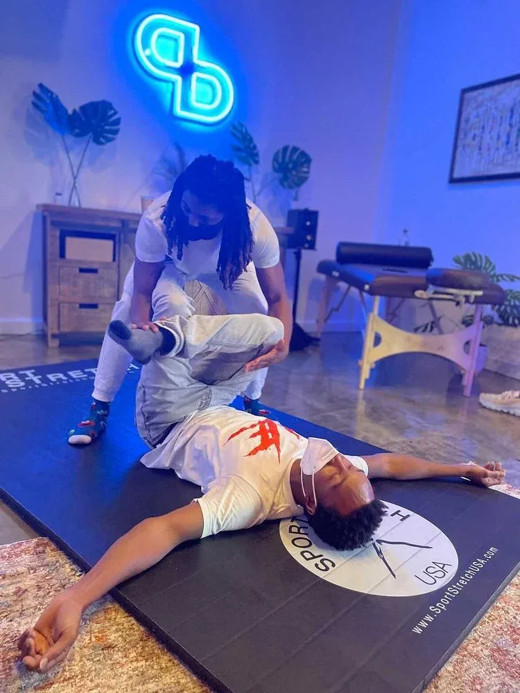 Therapist-led fascial stretch of a client's hip on the PreBodyworks table
